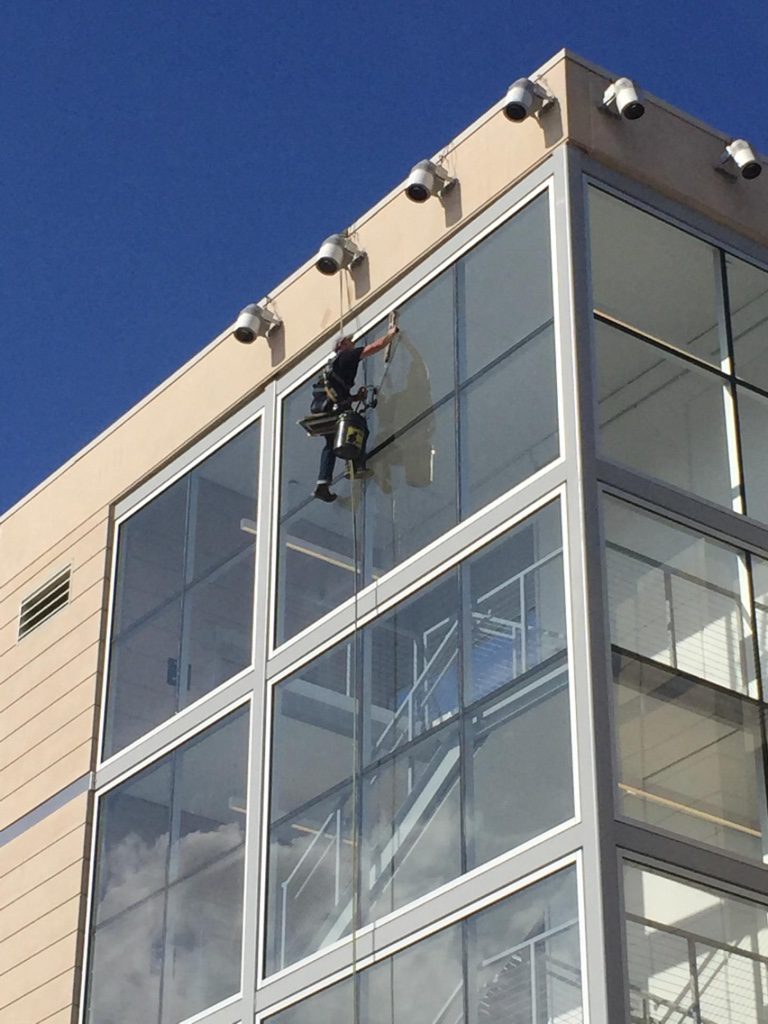 A man hanging from the side of a building.